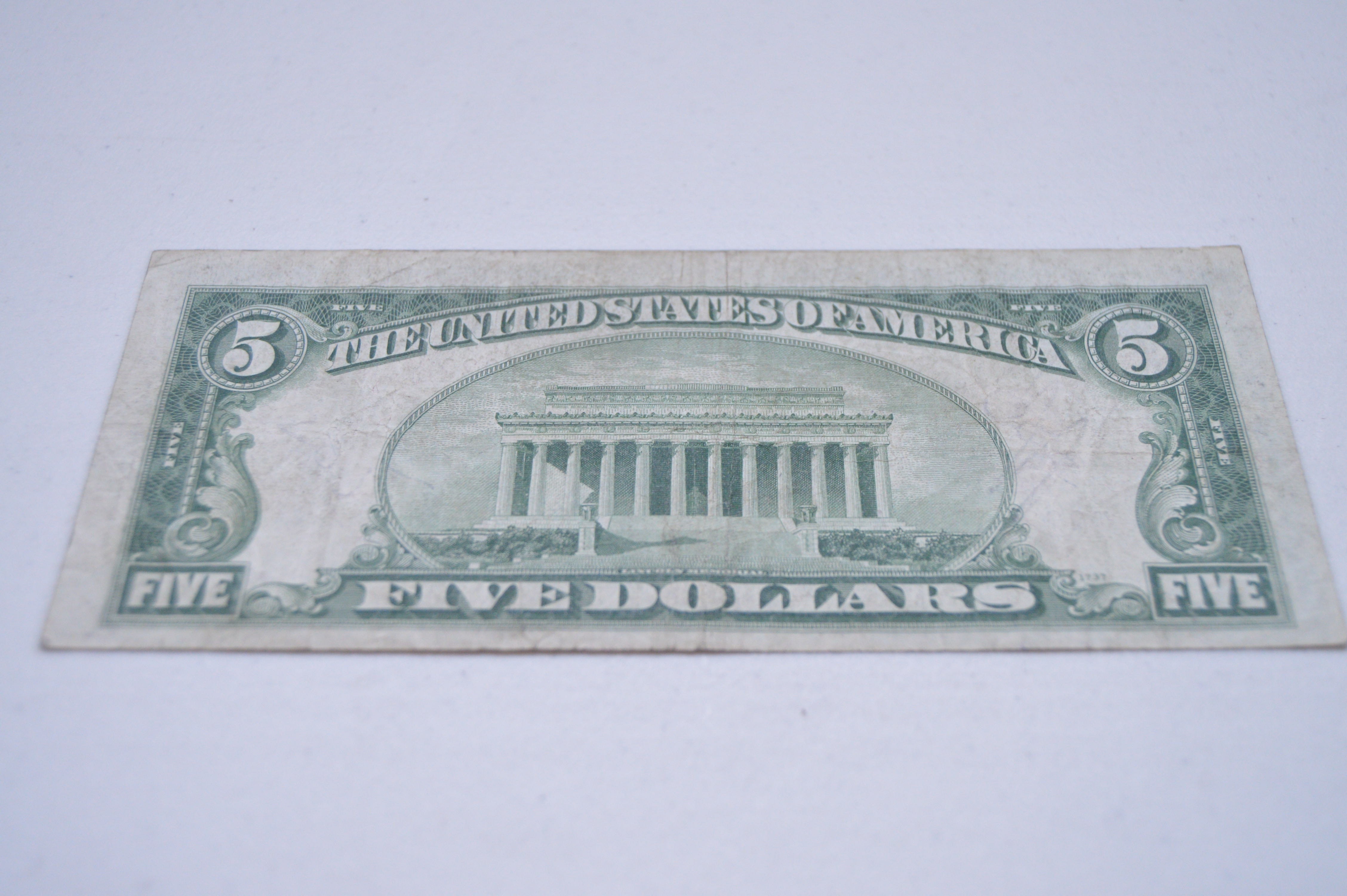 Five dollar bills with red serial numbers